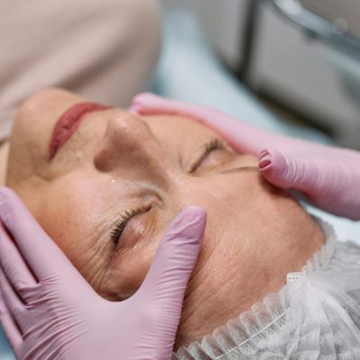 A serene spa therapy session with a senior woman enjoying a facial massage for rejuvenation.